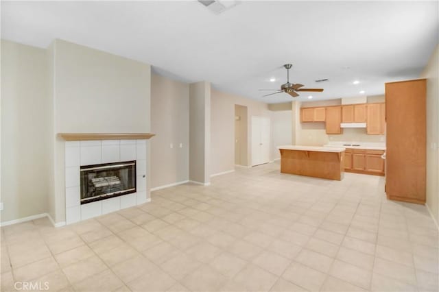 unfurnished living room with a fireplace and ceiling fan