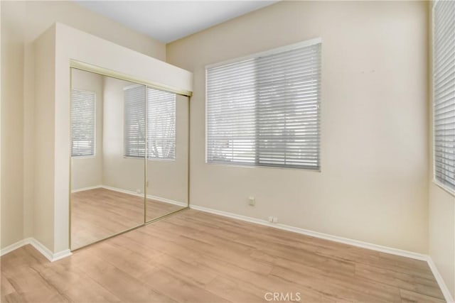 unfurnished bedroom with light hardwood / wood-style floors and a closet