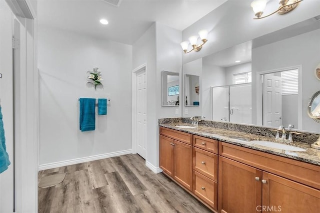 bathroom featuring vanity, hardwood / wood-style floors, and a shower with door