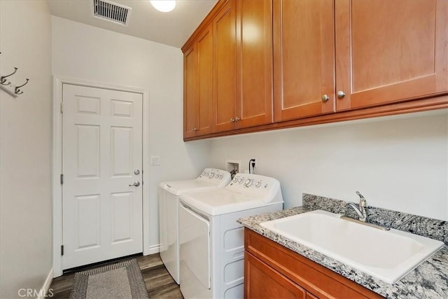 laundry area featuring washer and dryer, dark hardwood / wood-style floors, sink, and cabinets