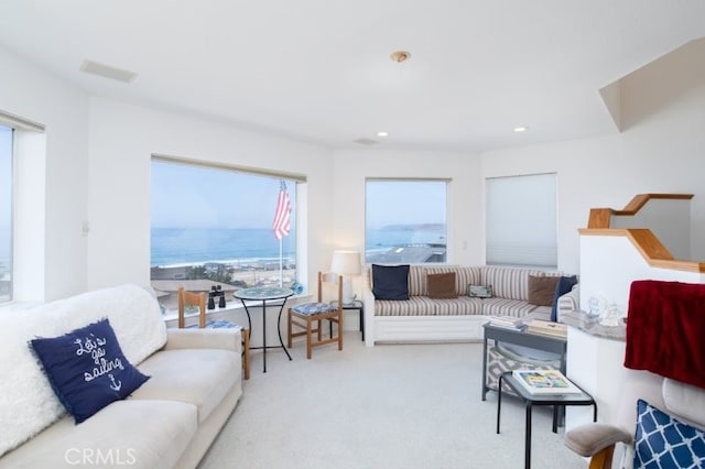 living room with a water view and light colored carpet