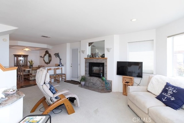 living room with carpet flooring, ceiling fan, and a high end fireplace