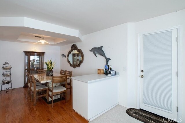 dining area featuring hardwood / wood-style floors and a tray ceiling