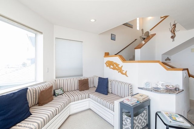 living area with recessed lighting, light colored carpet, and stairs