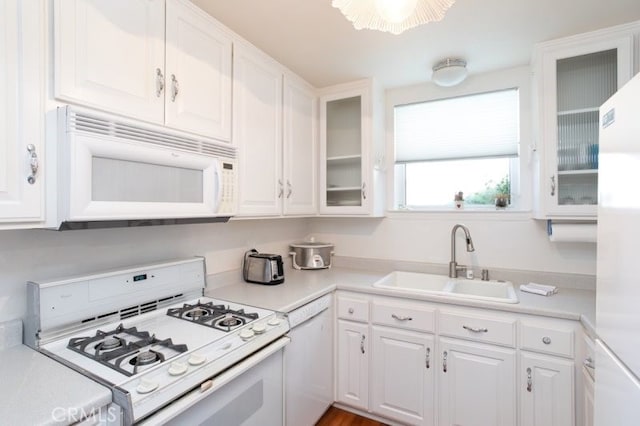 kitchen with white cabinets, white appliances, and sink