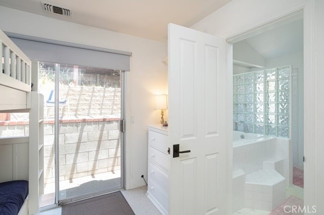 bathroom with a bath, lofted ceiling, and visible vents