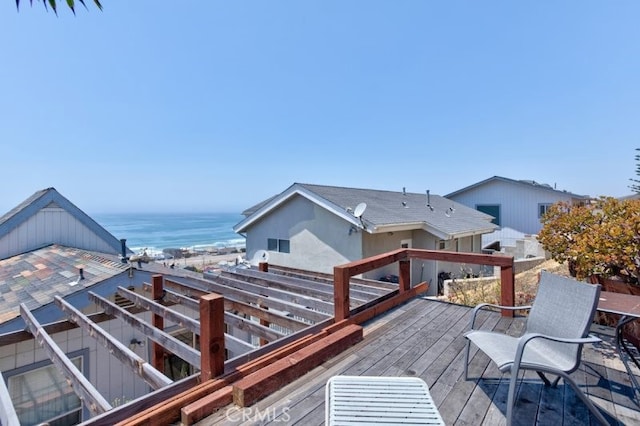 wooden terrace with a view of the beach and a water view