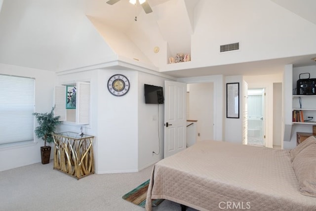 carpeted bedroom with ceiling fan, high vaulted ceiling, and ensuite bath