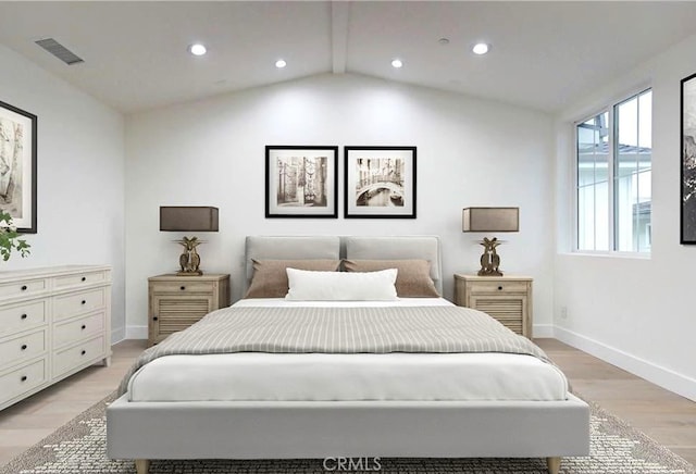 bedroom with lofted ceiling with beams and light wood-type flooring