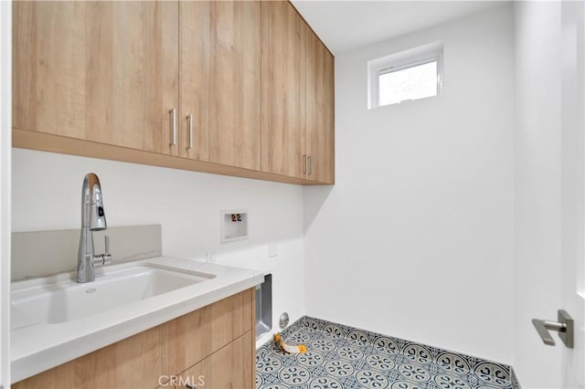 laundry room featuring light tile patterned flooring, cabinets, washer hookup, and sink