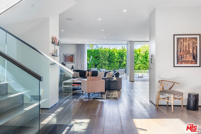 living room with dark wood-type flooring and floor to ceiling windows