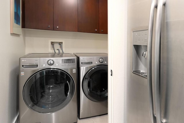 laundry room with washing machine and clothes dryer and cabinets