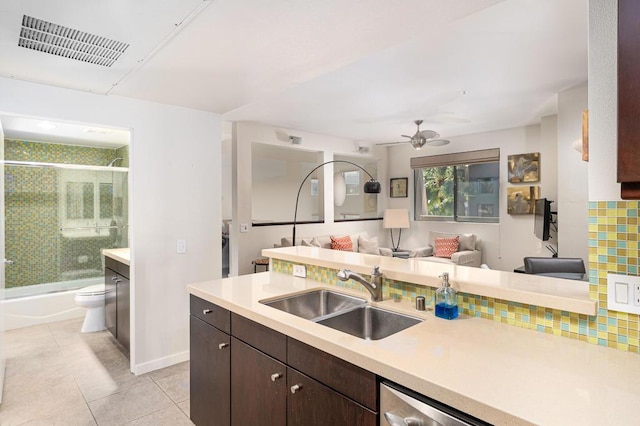 kitchen with stainless steel dishwasher, dark brown cabinetry, ceiling fan, sink, and light tile patterned flooring