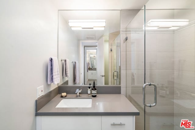 bathroom with vanity and a shower with shower door