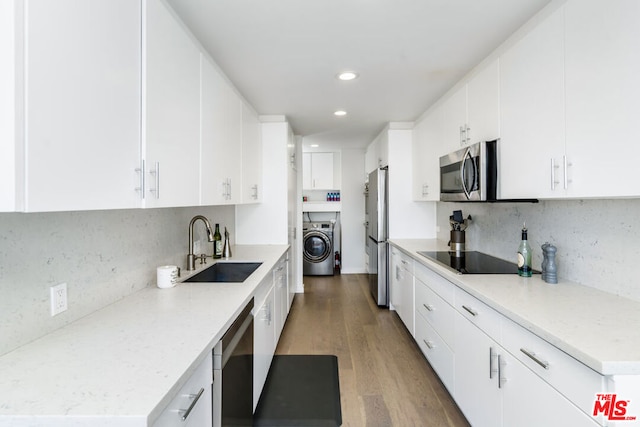 kitchen with sink, tasteful backsplash, white cabinetry, stainless steel appliances, and washer / clothes dryer