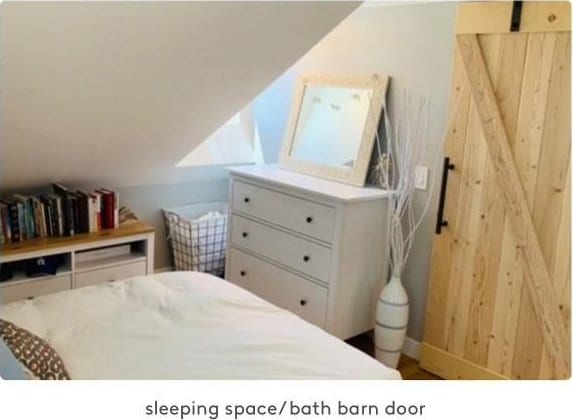 bedroom featuring a barn door and lofted ceiling