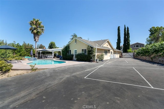 view of swimming pool with a hot tub and a patio area