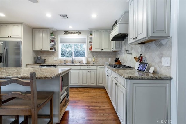 kitchen featuring a kitchen breakfast bar, light stone countertops, sink, and stainless steel appliances