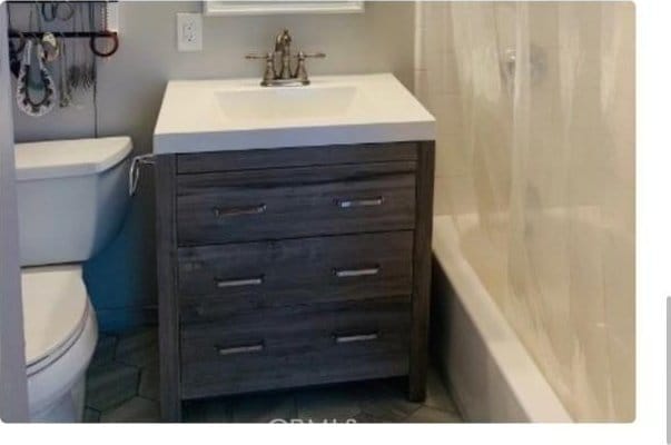 full bathroom featuring vanity, bathing tub / shower combination, and toilet