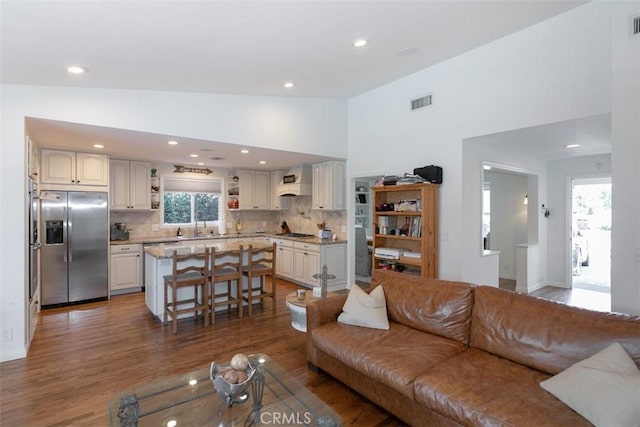 living room featuring high vaulted ceiling and dark wood-type flooring