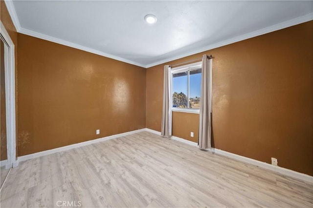 empty room featuring crown molding and light wood-type flooring