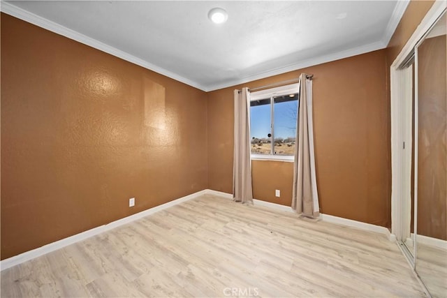 spare room with light wood-type flooring and ornamental molding