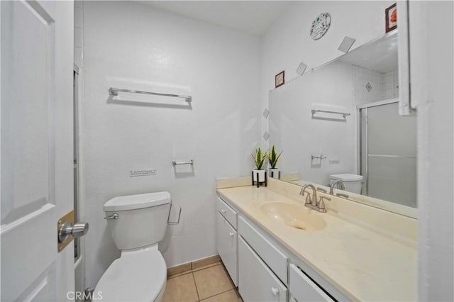 bathroom with tile patterned floors, vanity, a shower with shower door, and toilet