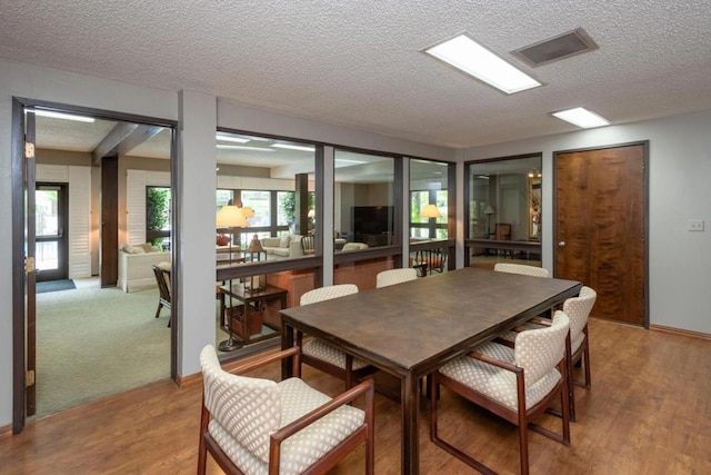 dining space with a textured ceiling and hardwood / wood-style flooring