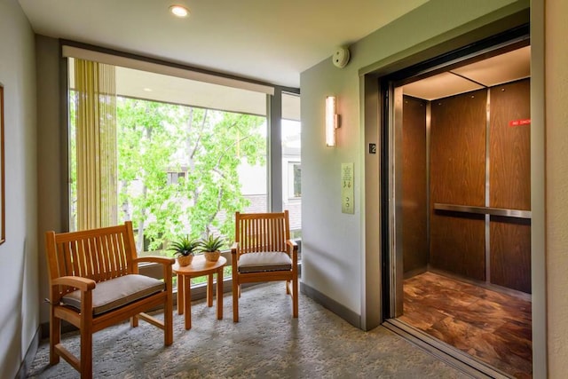 sitting room featuring expansive windows and elevator