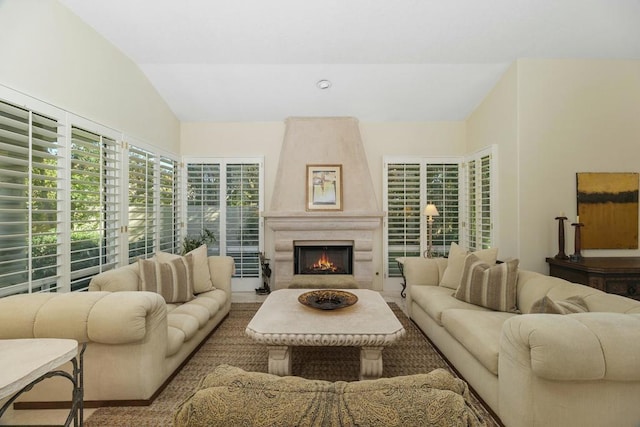 living room with a fireplace and vaulted ceiling