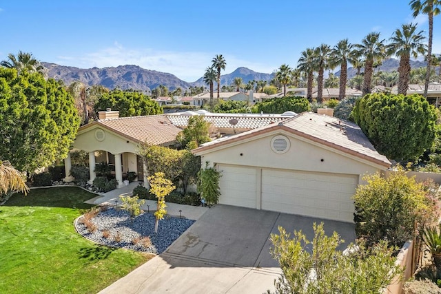 view of front of home featuring a garage, a mountain view, and a front yard