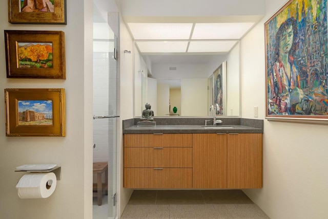 bathroom with tile patterned floors, vanity, and an enclosed shower