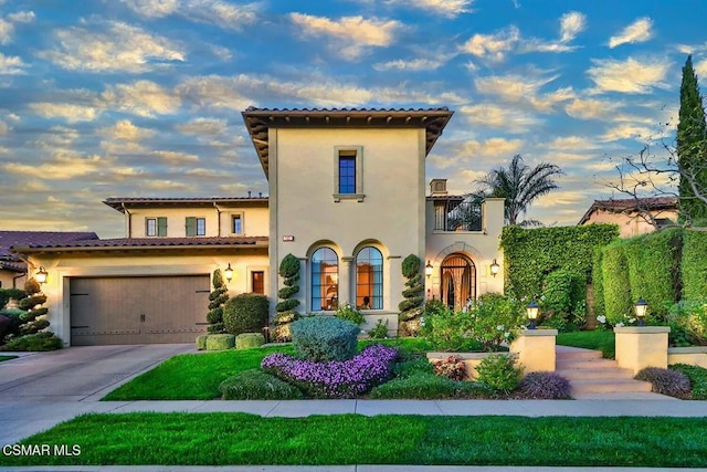 mediterranean / spanish house featuring a balcony and a garage