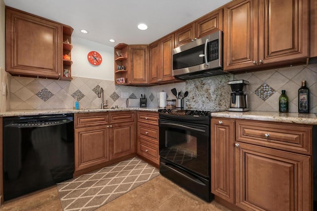 kitchen featuring tasteful backsplash, light stone countertops, sink, and black appliances