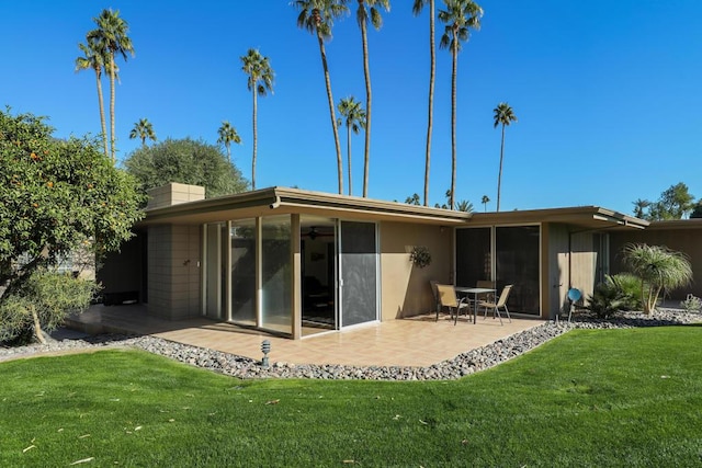 back of property featuring a yard and a patio area