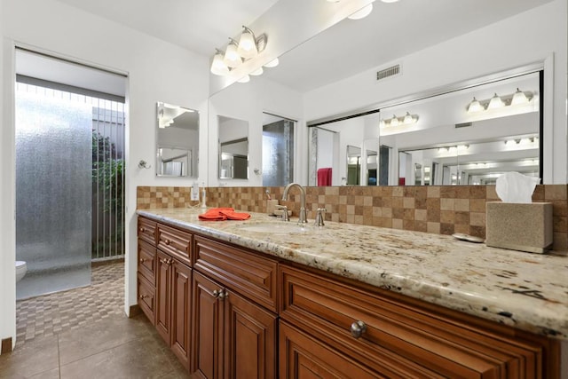 bathroom with tasteful backsplash, vanity, and tile patterned floors