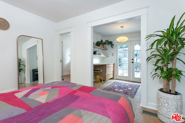 bedroom with access to exterior, french doors, and light hardwood / wood-style flooring