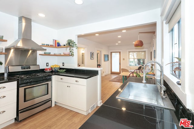 kitchen featuring white cabinets, sink, island exhaust hood, and gas range