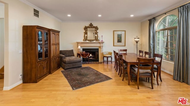 dining area featuring light hardwood / wood-style floors and ornamental molding