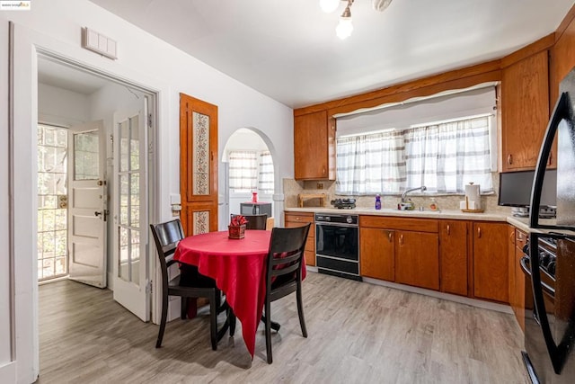 kitchen featuring sink, light wood-type flooring, and tasteful backsplash