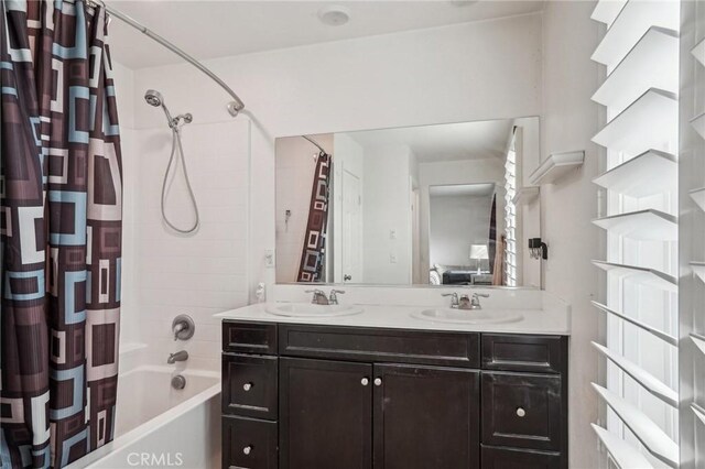 full bathroom with double vanity, shower / tub combo, and a sink