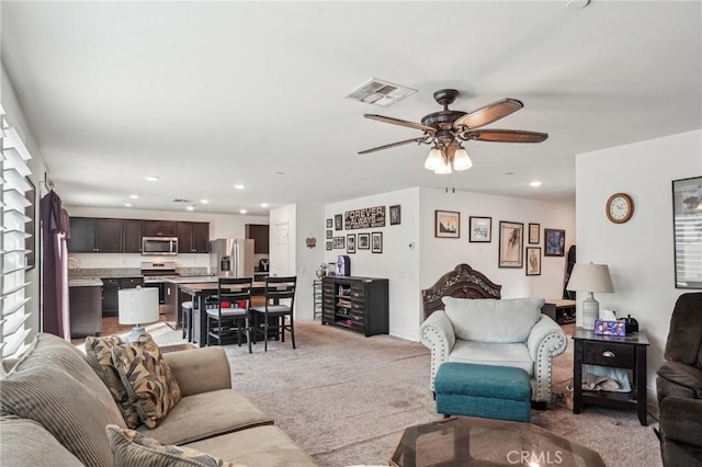 living area with light carpet, ceiling fan, visible vents, and recessed lighting