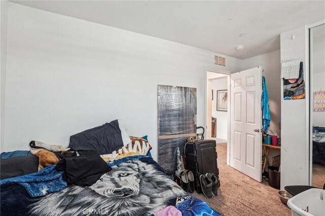 carpeted bedroom with a closet and visible vents