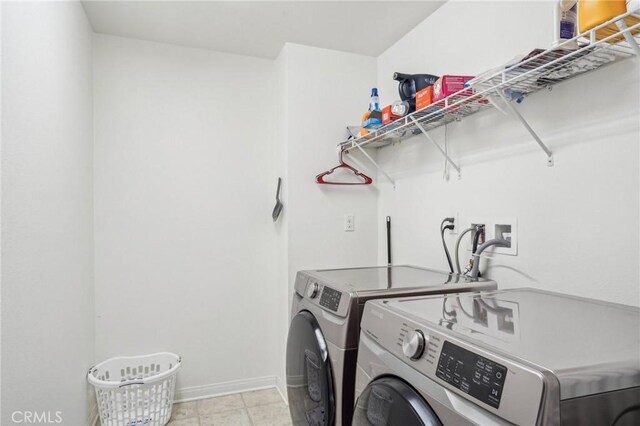 washroom featuring laundry area, baseboards, and independent washer and dryer