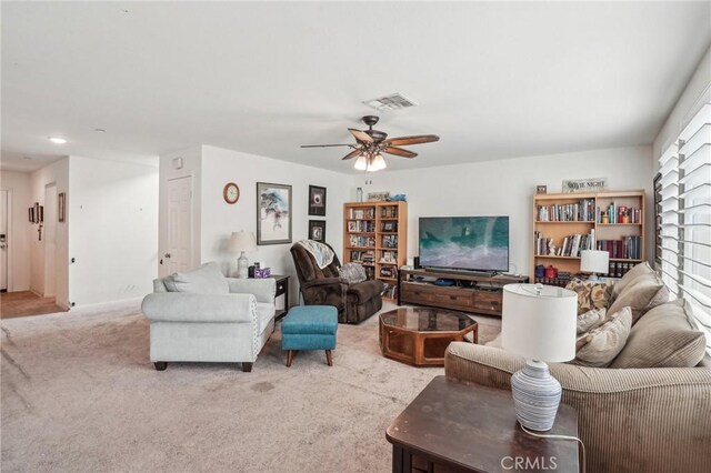 carpeted living room with visible vents and a ceiling fan