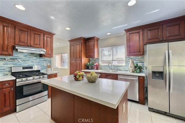 kitchen with light tile patterned floors, appliances with stainless steel finishes, a kitchen island, and sink