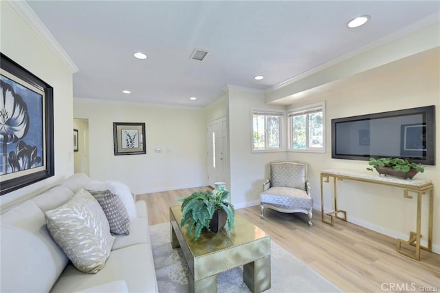 living room with ornamental molding and light hardwood / wood-style flooring