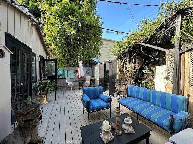 deck featuring an outdoor living space and a storage unit