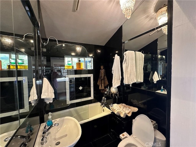 bathroom with tiled tub and toilet