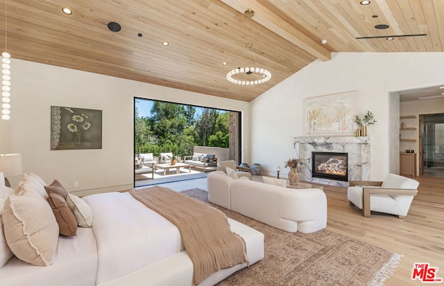 bedroom with a fireplace, lofted ceiling with beams, hardwood / wood-style floors, and wood ceiling